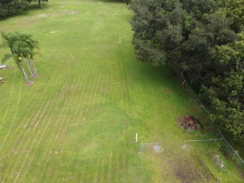 aerial view from driveway showing property with beginning of fence